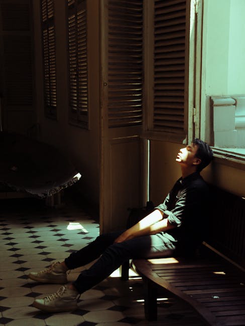 Man resting on bench, sunlight illuminating him; healing journey. Breaking free from childhood trauma