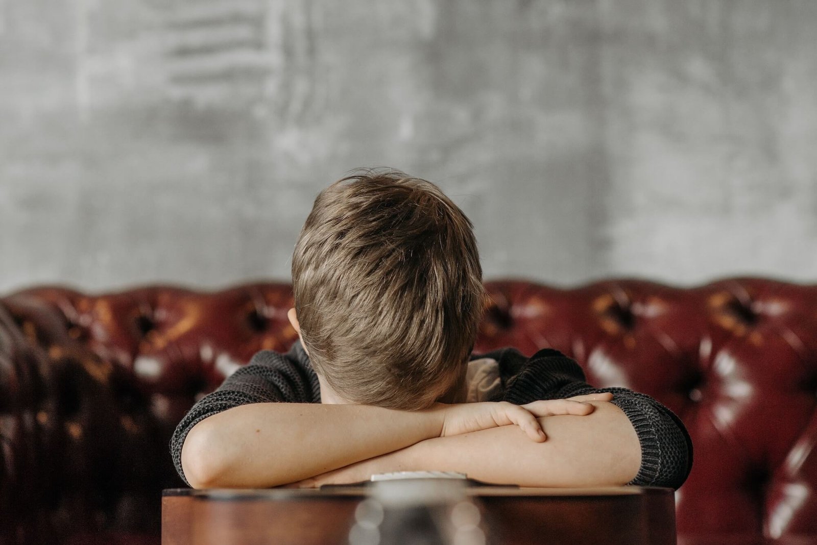 Child resting his head on his folded arms